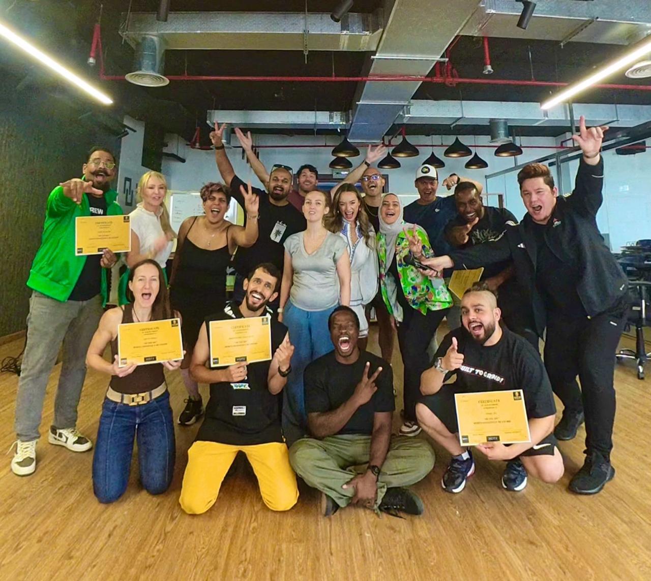 On The Mic group celebrating with certificates